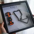 Person holding a tablet displaying a Formula 1 car and track layout.