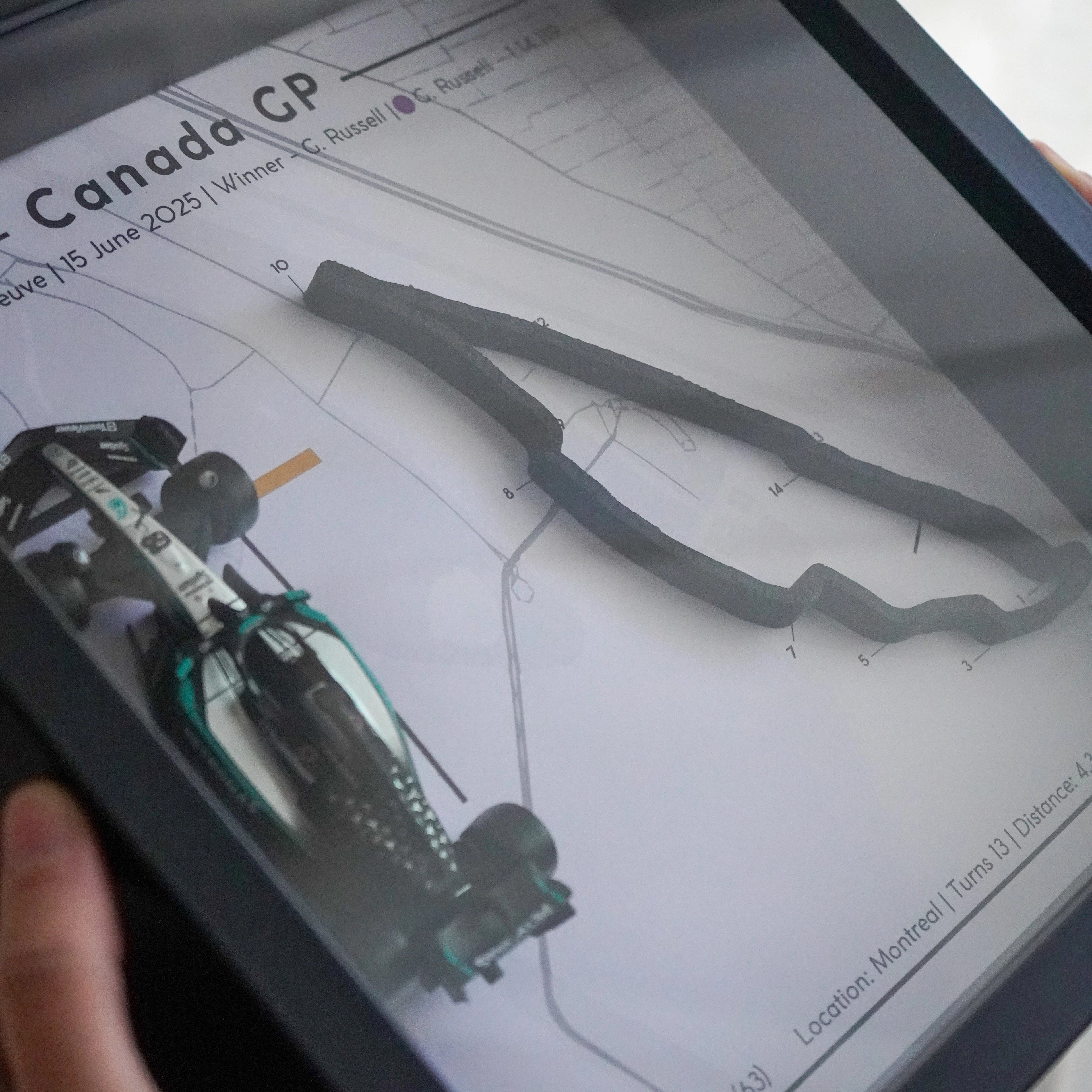Person holding a framed document with technical drawings and 'Canada GP' text.