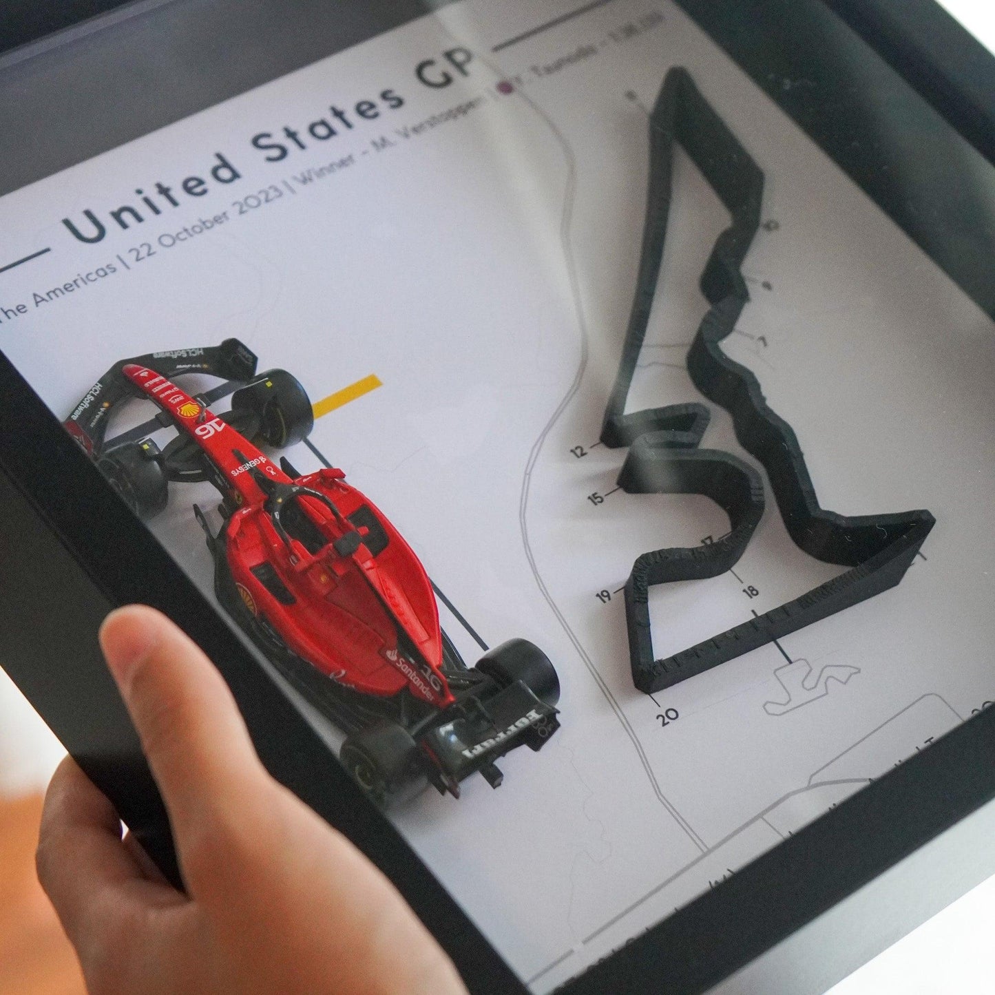 F1-themed frame featuring a 1:43 scale Leclerc's car on the America GP track. Includes a 3D-printed track replica with real elevation changes and a satellite map background