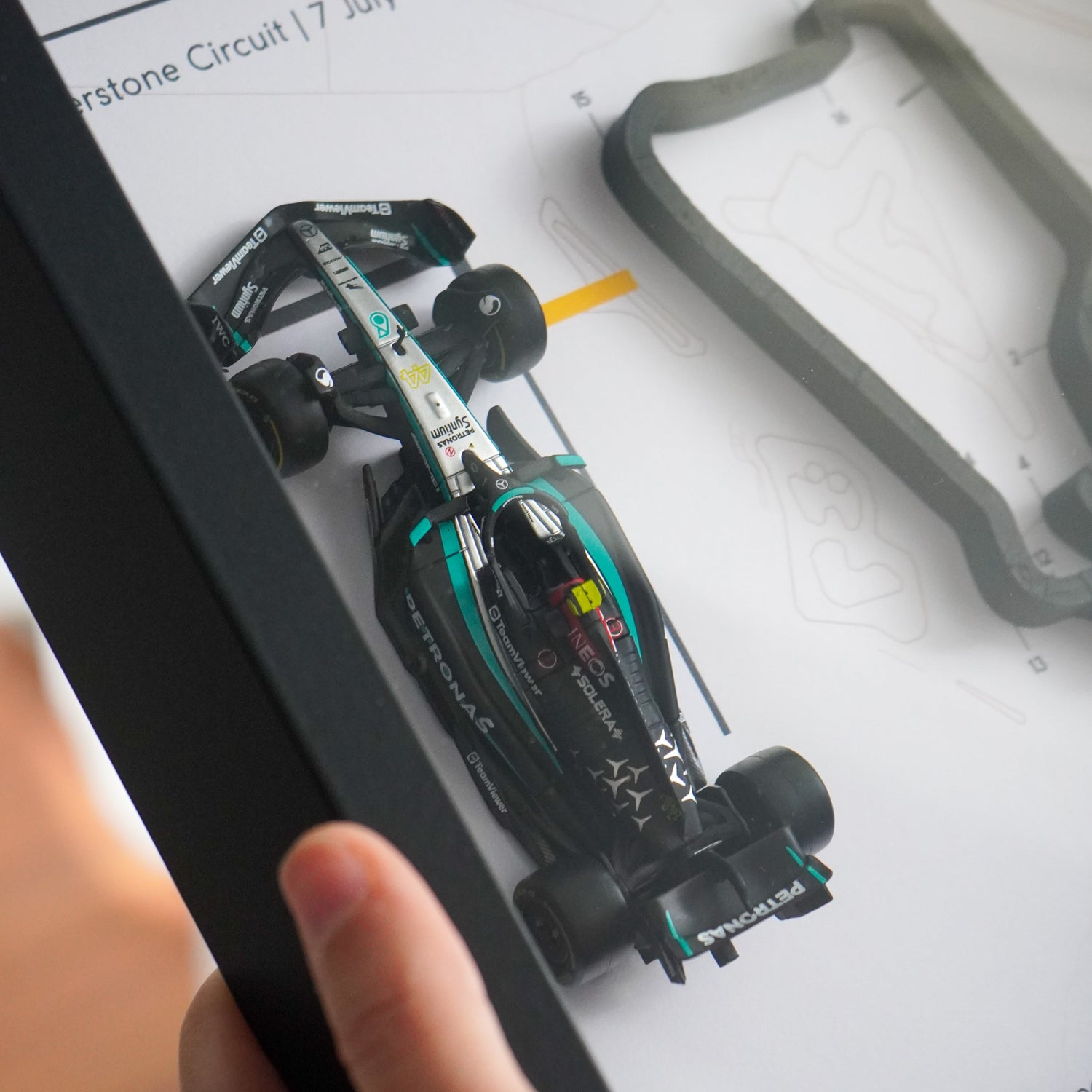 F1-themed frame featuring a 1:43 scale Hamilton's car on the British GP track. Includes a 3D-printed track replica with real elevation changes and a satellite map background