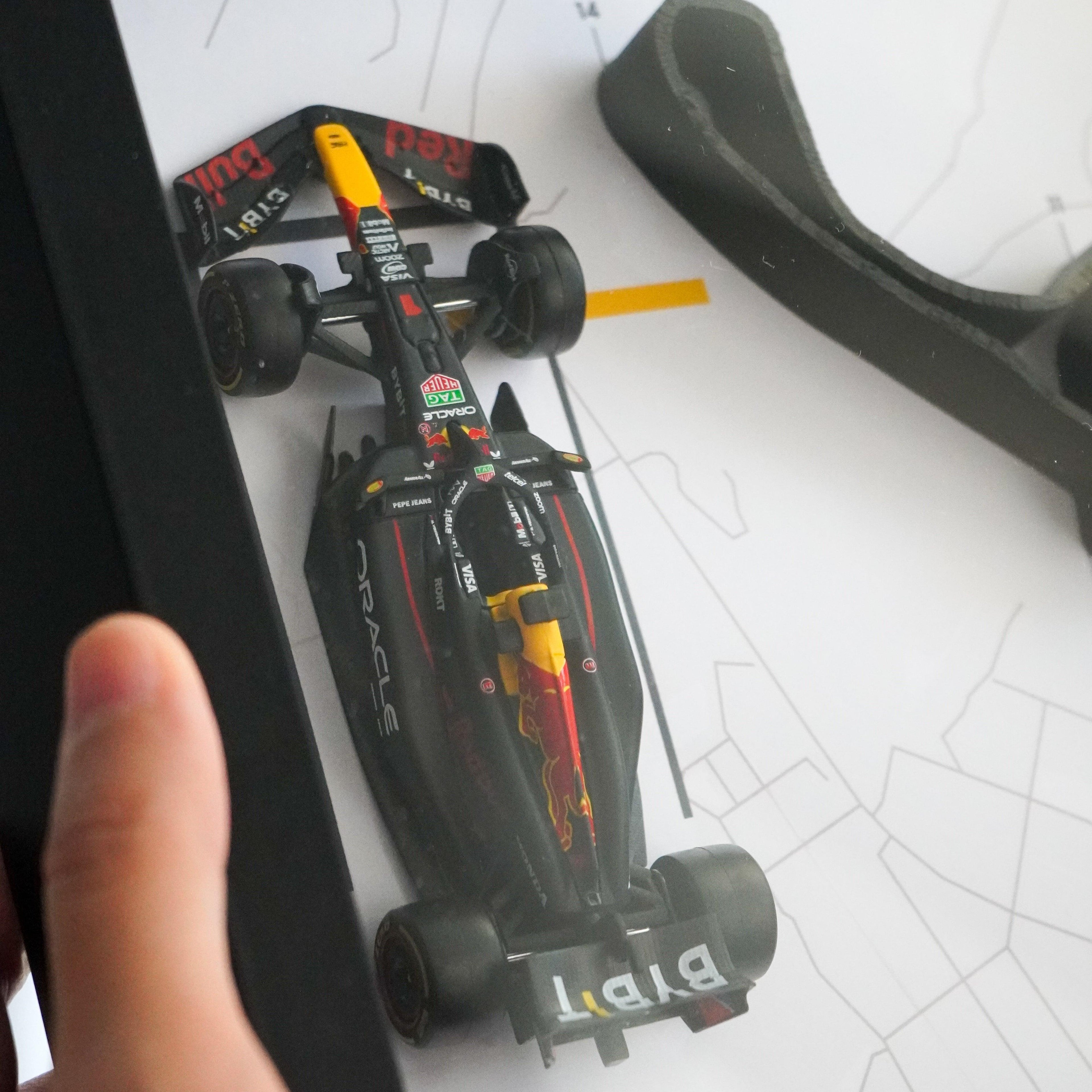 F1-themed frame featuring a 1:43 scale Max Verstappen's car on the Japanese GP track. Includes a 3D-printed track replica with real elevation changes and a satellite map background