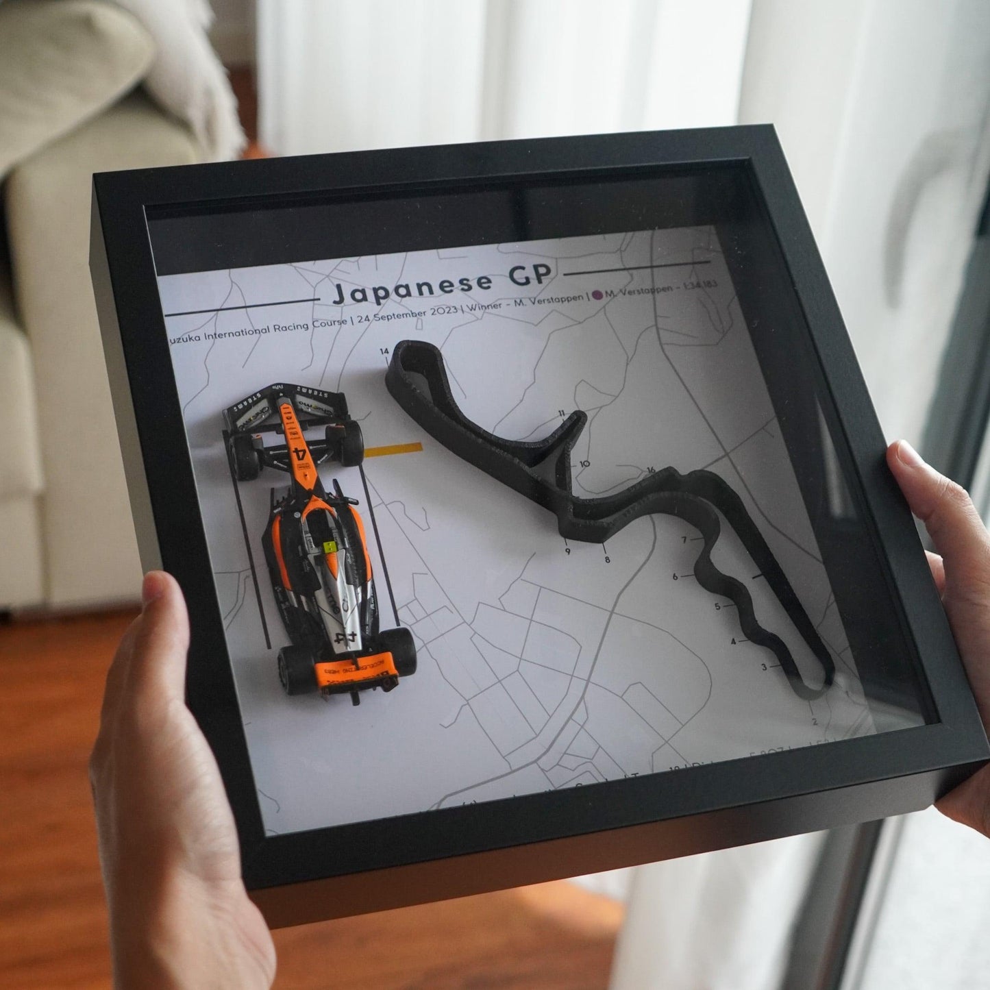 F1-themed frame featuring a 1:43 scale Norris's car on the Japanase GP track. Includes a 3D-printed track replica with real elevation changes and a satellite map background