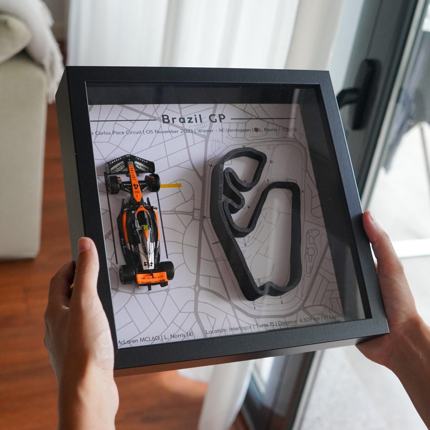 F1-themed frame featuring a 1:43 scale Norris's car on the Brazil GP track. Includes a 3D-printed track replica with real elevation changes and a satellite map background