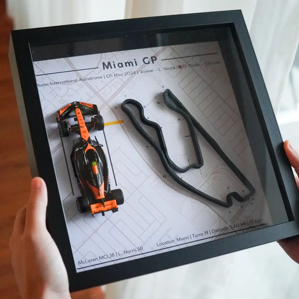 F1-themed frame featuring a 1:43 scale Norris's car on the Miami GP track. Includes a 3D-printed track replica with real elevation changes and a satellite map background