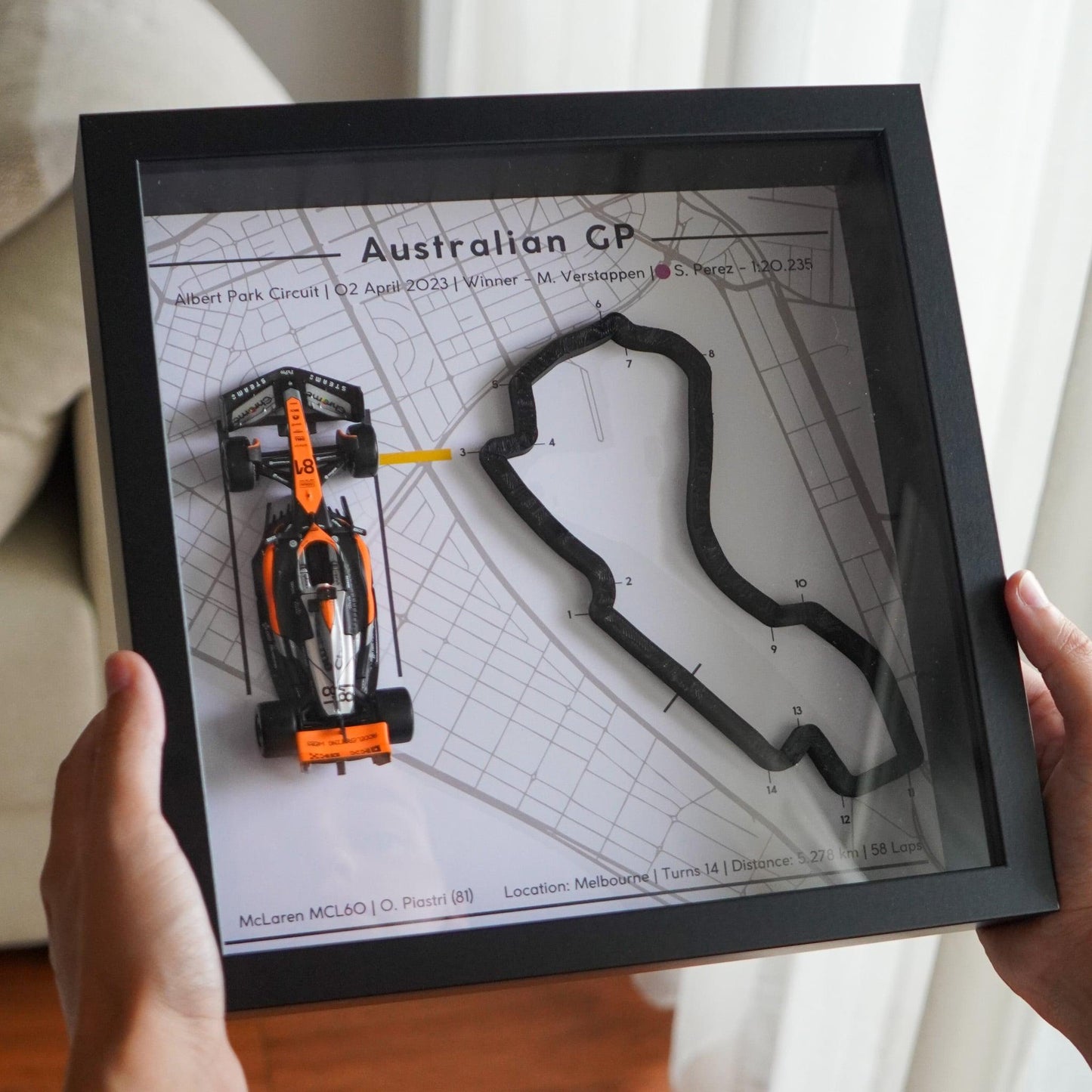 F1-themed frame featuring a 1:43 scale Piastri's car on the Australian GP track. Includes a 3D-printed track replica with real elevation changes and a satellite map background