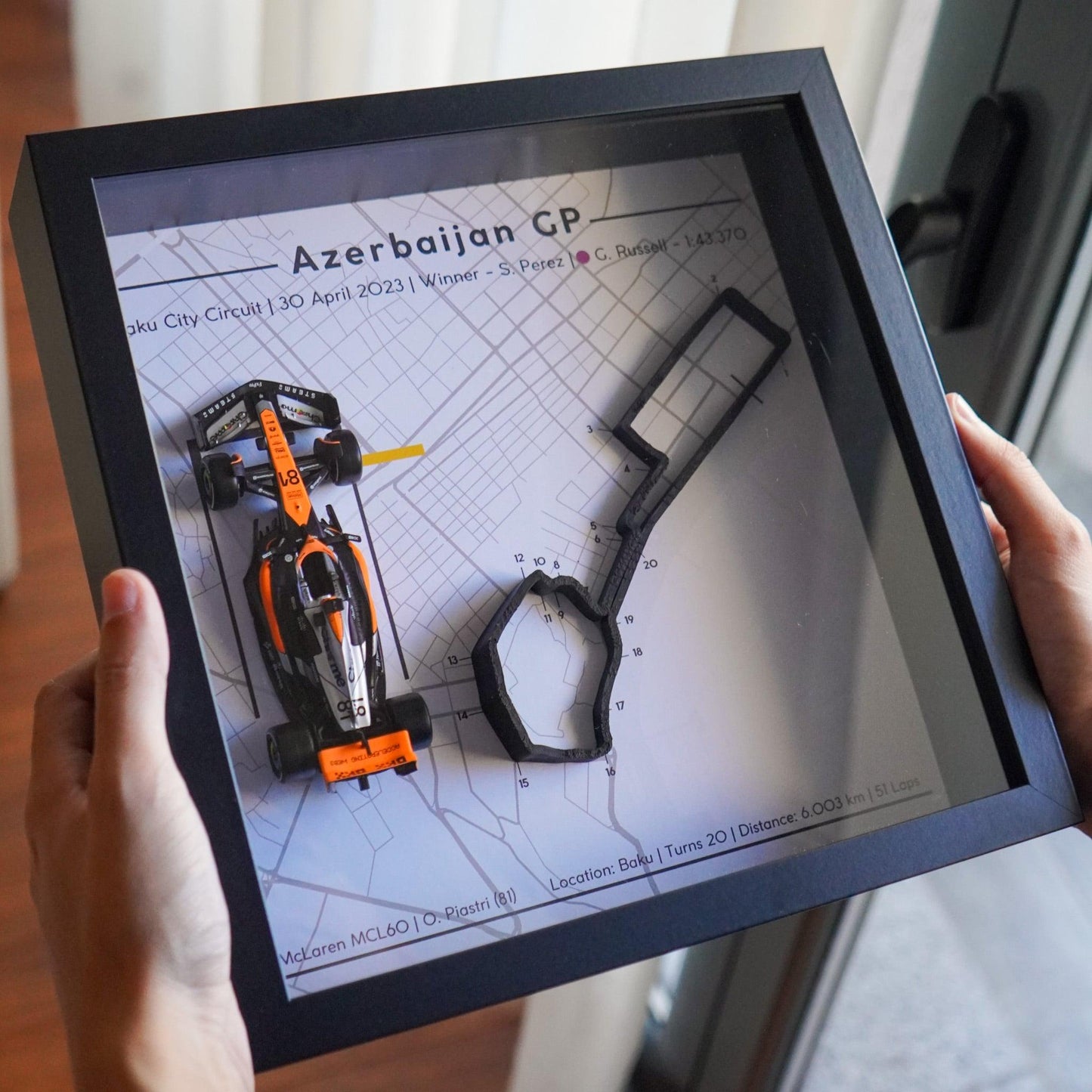 F1-themed frame featuring a 1:43 scale Piastri's car on the Azerbaijan GP track. Includes a 3D-printed track replica with real elevation changes and a satellite map background