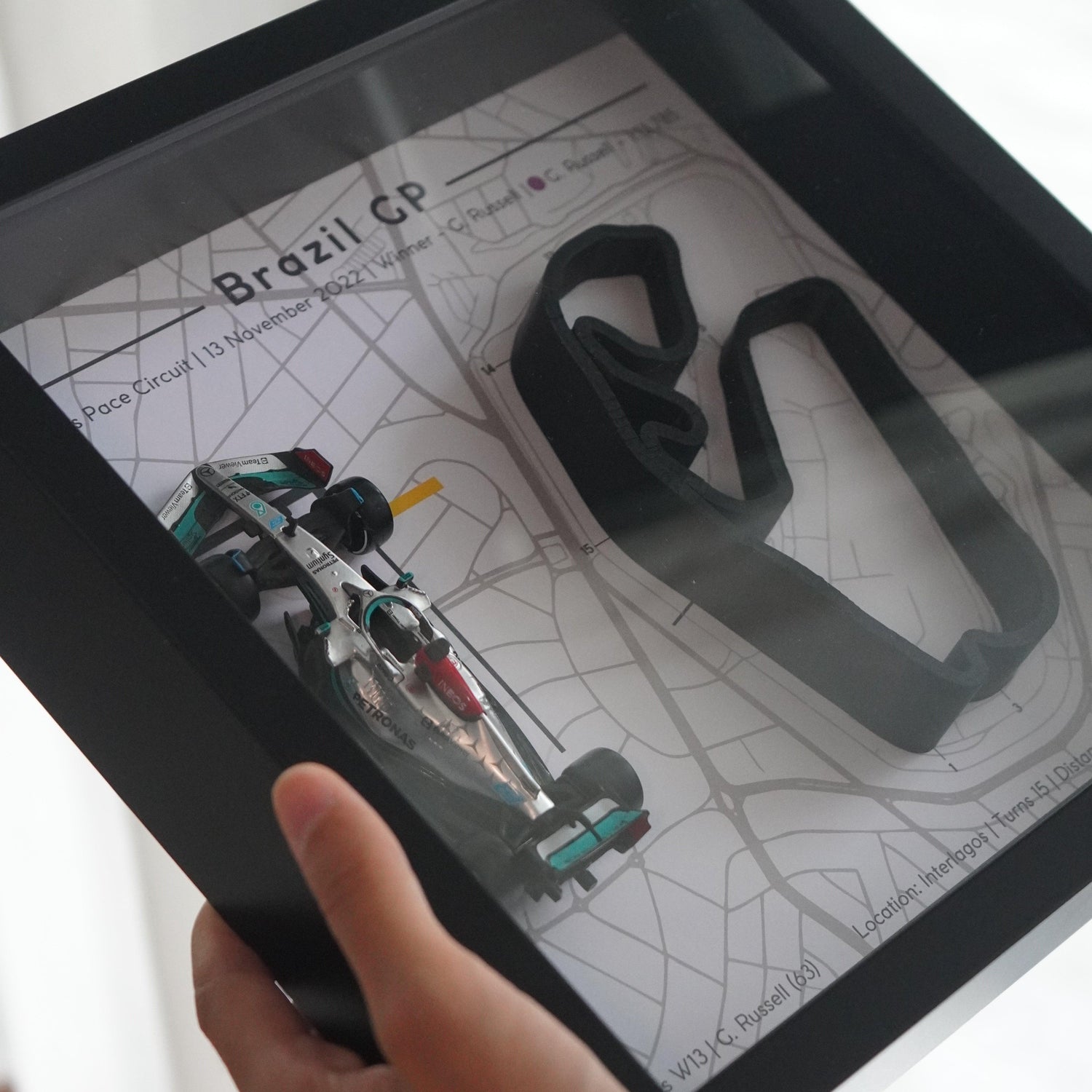 F1-themed frame featuring a 1:43 scale Russell's car on the Brazil GP track. Includes a 3D-printed track replica with real elevation changes and a satellite map background