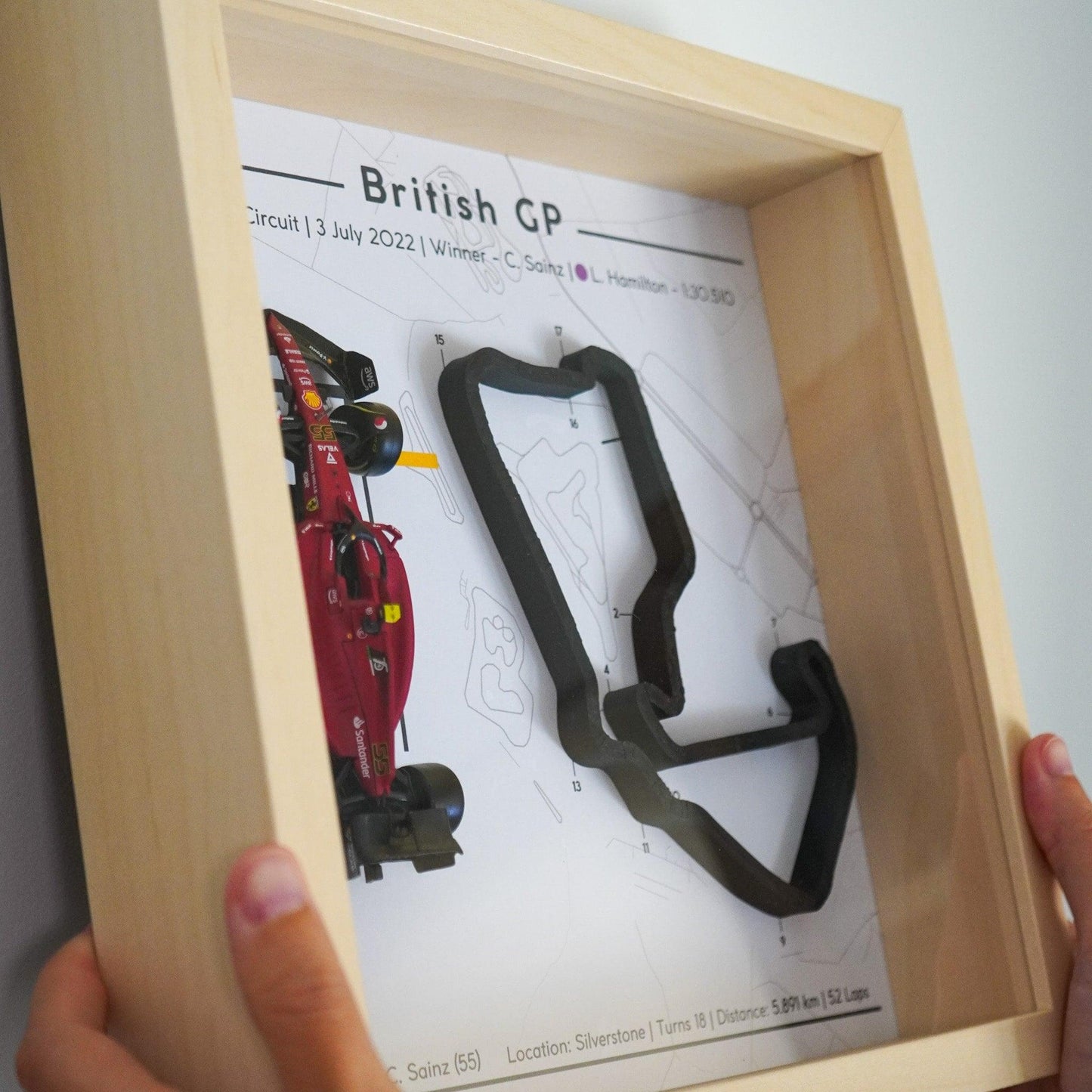 F1-themed frame featuring a 1:43 scale Sainz's car on the British GP track. Includes a 3D-printed track replica with real elevation changes and a satellite map background