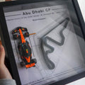 Framed poster of a race car and track layout with 'Abu Dhabi GP' text.